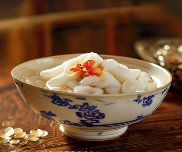 一碗白嫩细腻的91豆花盛在青花瓷碗中，淋上金黄红糖姜汁，撒上桂花，背景是温暖的木质传统厨房，光线柔和温馨，正宗豆花美食氛围感十足